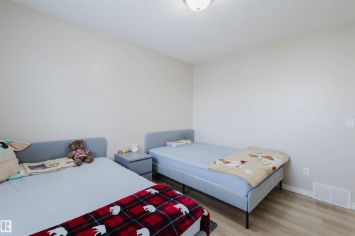 Bedroom with wood finished floors and baseboards - 8420 Sloane Crescent, Edmonton, AB - Indoor Photo Showing Bedroom