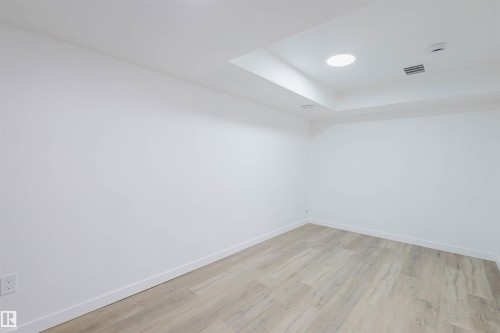 Empty room with light wood finished floors, recessed lighting, and a raised ceiling - 8420 Sloane Crescent, Edmonton, AB - Indoor Photo Showing Other Room