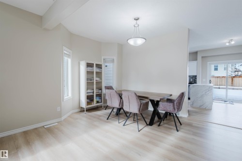 Dining area featuring light wood finished floors and beamed ceiling - 8420 Sloane Crescent, Edmonton, AB - Indoor Photo Showing Dining Room