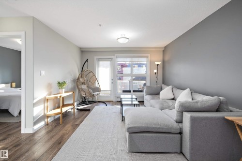 Living area featuring wood finished floors and baseboards - 205 8515 99 Street, Edmonton, AB - Indoor