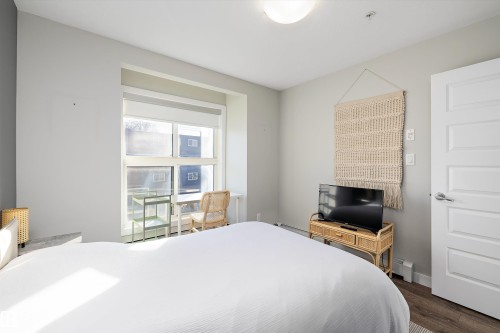 Bedroom featuring dark wood finished floors and a baseboard radiator - 205 8515 99 Street, Edmonton, AB - Indoor Photo Showing Bedroom