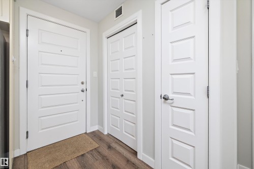 Doorway with baseboards and wood finished floors - 205 8515 99 Street, Edmonton, AB - Indoor Photo Showing Other Room