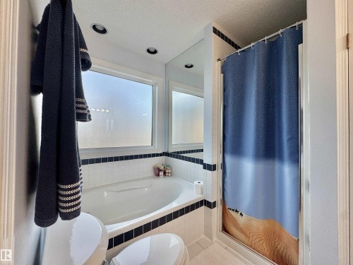 Full bath with a shower stall, a bath, and a textured ceiling - 3772 30 Street, Edmonton, AB - Indoor Photo Showing Bathroom