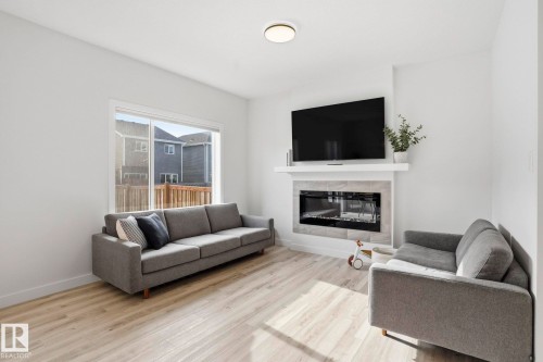Living area with wood finished floors and a fireplace - 16627 31 Avenue, Edmonton, AB - Indoor Photo Showing Living Room With Fireplace