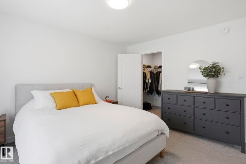 Bedroom featuring light carpet and a walk in closet - 16627 31 Avenue, Edmonton, AB - Indoor Photo Showing Bedroom