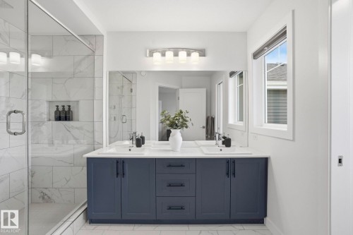 Full bathroom featuring double vanity, a stall shower, and light marble finish flooring - 16627 31 Avenue, Edmonton, AB - Indoor Photo Showing Bathroom