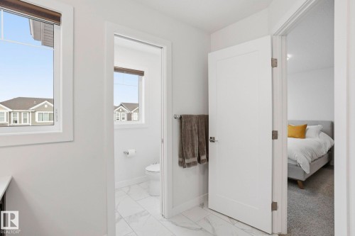 Bathroom featuring light marble finish flooring, ensuite bathroom, and vanity - 16627 31 Avenue, Edmonton, AB - Indoor