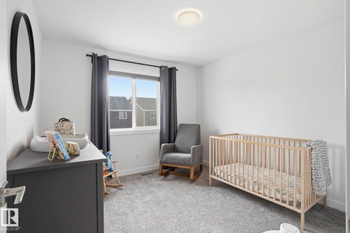 Bedroom with a crib and light carpet - 16627 31 Avenue, Edmonton, AB - Indoor Photo Showing Bedroom