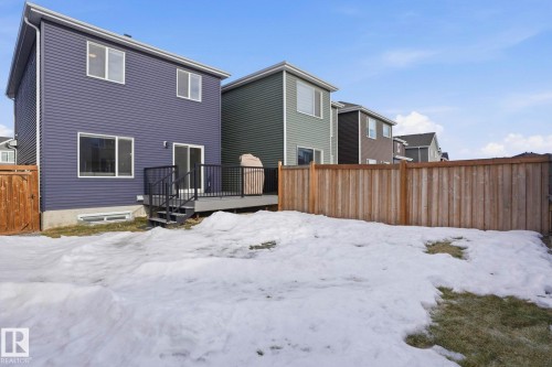 Snow covered property featuring a fenced backyard, a wooden deck, and a gate - 16627 31 Avenue, Edmonton, AB - Outdoor