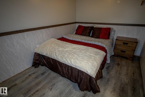 Bedroom with a wainscoted wall and wood finished floors - 56430 Range Rd 113, Rural St. Paul County, AB - Indoor Photo Showing Bedroom