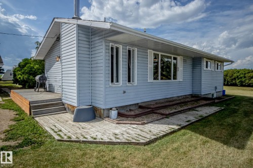 View of property exterior with a wooden deck and a lawn - 56430 Range Rd 113, Rural St. Paul County, AB - Outdoor