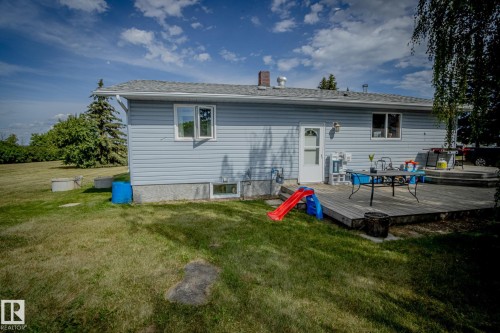 Back of house featuring a yard, a wooden deck, a chimney, and roof with shingles - 56430 Range Rd 113, Rural St. Paul County, AB - Outdoor
