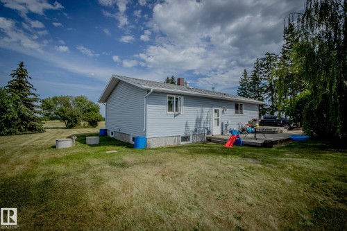 Rear view of property with a yard, a wooden deck, and a chimney - 56430 Range Rd 113, Rural St. Paul County, AB - Outdoor