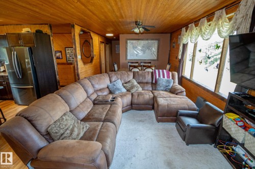 Living room featuring wooden walls, a ceiling fan, and wooden ceiling - 56430 Range Rd 113, Rural St. Paul County, AB - Indoor Photo Showing Living Room