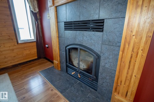 Detailed view of wood finished floors and a tiled fireplace - 56430 Range Rd 113, Rural St. Paul County, AB - Indoor With Fireplace