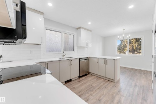 Kitchen featuring decorative backsplash, a peninsula, light wood-style flooring, and plenty of natural light - 14511 21 St., Edmonton, AB - Indoor Photo Showing Kitchen