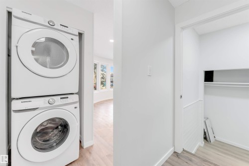 Laundry area featuring light wood-style flooring, stacked washer / dryer, and recessed lighting - 14511 21 St., Edmonton, AB - Indoor Photo Showing Laundry Room
