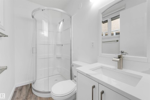 Full bathroom with a shower stall, vanity, and wood finished floors - 14511 21 St., Edmonton, AB - Indoor Photo Showing Bathroom