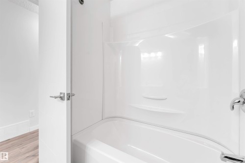 Bathroom with tub / shower combination and wood finished floors - 14511 21 St., Edmonton, AB - Indoor Photo Showing Bathroom