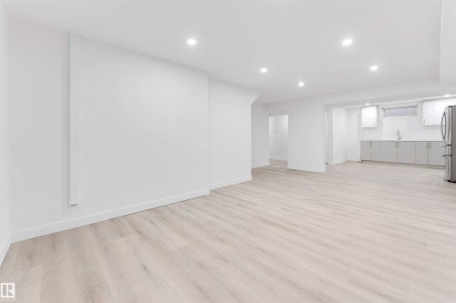 Finished basement featuring recessed lighting, light wood finished floors, and freestanding refrigerator - 14511 21 St., Edmonton, AB - Indoor Photo Showing Other Room