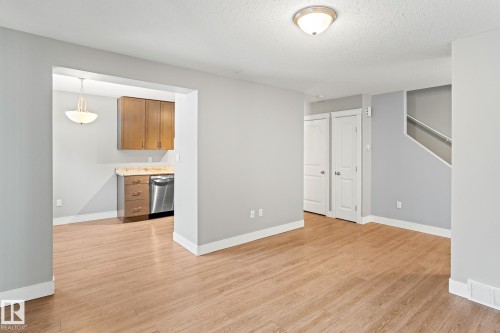 Unfurnished living room with light wood-type flooring and a textured ceiling - 914 9 Street, Cold Lake, AB - Indoor