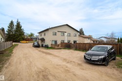 Two-story property featuring a neutral-toned exterior, multiple windows, and a rear deck - 