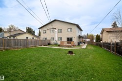 Expansive green lawn with wooden privacy fencing - 