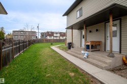 Two-story exterior featuring tan horizontal siding, a covered porch entry, and a concrete walkway - 