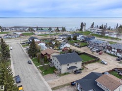 Aerial perspective showcasing a residential neighborhood with water frontage - 