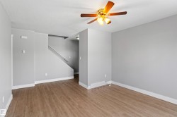 Empty room with light wood-type flooring and a ceiling fan - 