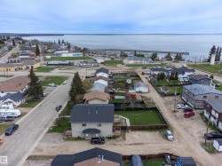 Aerial perspective showcasing a community with nearby water, residential properties, and commercial buildings - 