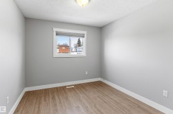 Empty room featuring light wood finished floors and a textured ceiling - 