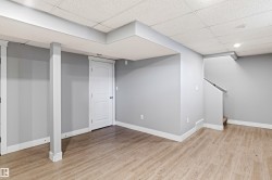 Finished below grade area featuring a drop ceiling and light wood-style floors - 