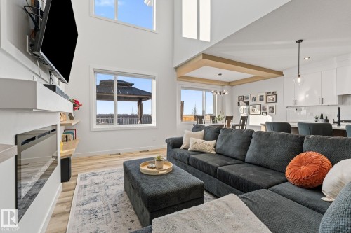 Living room with light wood-style floors, a fireplace, and a high ceiling - 342 Meadowview Drive, Fort Saskatchewan, AB - Indoor Photo Showing Living Room