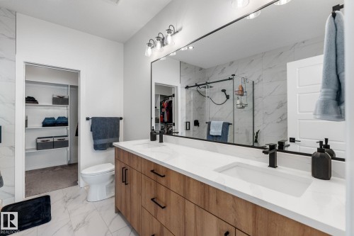 Full bath featuring a walk in closet, light marble finish floors, a marble finish shower, and double vanity - 342 Meadowview Drive, Fort Saskatchewan, AB - Indoor Photo Showing Bathroom
