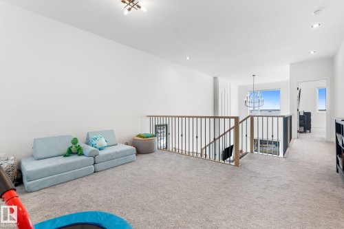 Living area with carpet flooring, an upstairs landing, and hanging lights - 342 Meadowview Drive, Fort Saskatchewan, AB - Indoor Photo Showing Other Room