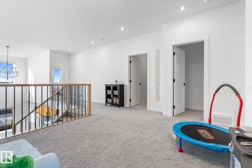 Recreation room with light colored carpet and hanging lights - 342 Meadowview Drive, Fort Saskatchewan, AB - Indoor Photo Showing Other Room