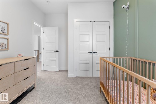 Bedroom featuring a crib, light carpet, and a closet - 342 Meadowview Drive, Fort Saskatchewan, AB - Indoor