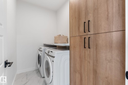 Laundry room with cabinet space, washer and clothes dryer, and light marble finish flooring - 342 Meadowview Drive, Fort Saskatchewan, AB - Indoor Photo Showing Laundry Room