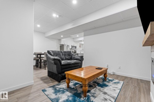 Living area featuring light wood-type flooring and a drop ceiling - 342 Meadowview Drive, Fort Saskatchewan, AB - Indoor Photo Showing Living Room With Fireplace