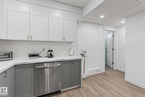 Kitchen featuring dual tone cabinetry, dishwasher, light wood-type flooring, recessed lighting, and light stone counters - 342 Meadowview Drive, Fort Saskatchewan, AB - Indoor