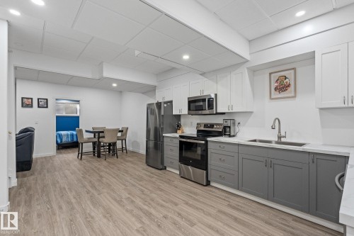 Kitchen featuring two tone cabinets, stainless steel appliances, a drop ceiling, light wood-style flooring, and recessed lighting - 342 Meadowview Drive, Fort Saskatchewan, AB - Indoor Photo Showing Kitchen