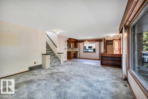 Unfurnished living room with carpet flooring and suspended lighting - 4314 52 Street, Wetaskiwin, AB - Indoor Photo Showing Other Room