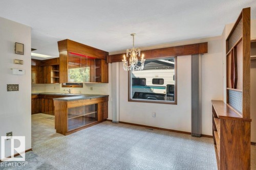 Kitchen with open shelves, wood finish cabinetry, a chandelier, light floors, and a peninsula - 4314 52 Street, Wetaskiwin, AB - Indoor