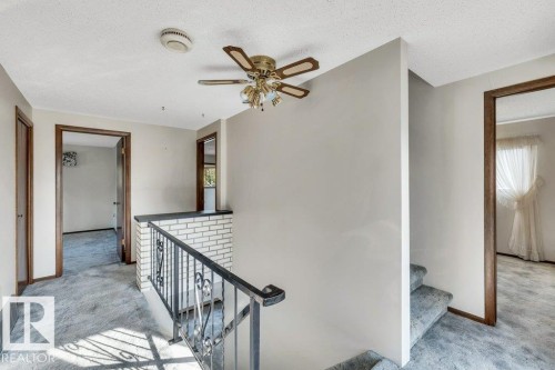 Stairs with carpet flooring, a textured ceiling, and a ceiling fan - 4314 52 Street, Wetaskiwin, AB - Indoor Photo Showing Other Room