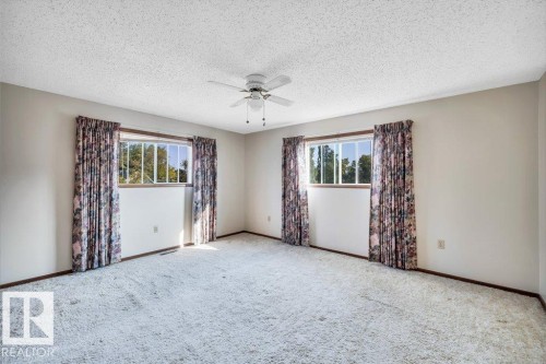 Empty room with ceiling fan, carpet floors, and a textured ceiling - 4314 52 Street, Wetaskiwin, AB - Indoor Photo Showing Other Room