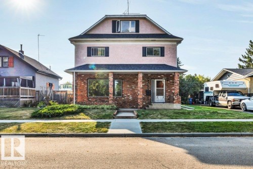 View of front of house featuring a porch, a front lawn, brick siding, and stucco siding - 4314 52 Street, Wetaskiwin, AB - Outdoor With Deck Patio Veranda
