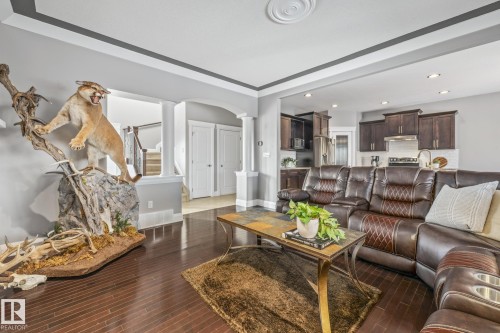 Living area with arched walkways, ornate columns, dark wood-style floors, and recessed lighting - 167 Bremner Crescent, Fort Saskatchewan, AB - Indoor Photo Showing Living Room