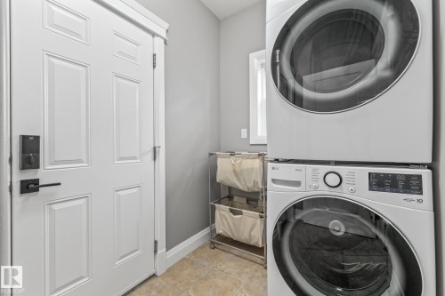 Laundry area featuring stacked washer and dryer and baseboards - 167 Bremner Crescent, Fort Saskatchewan, AB - Indoor Photo Showing Laundry Room