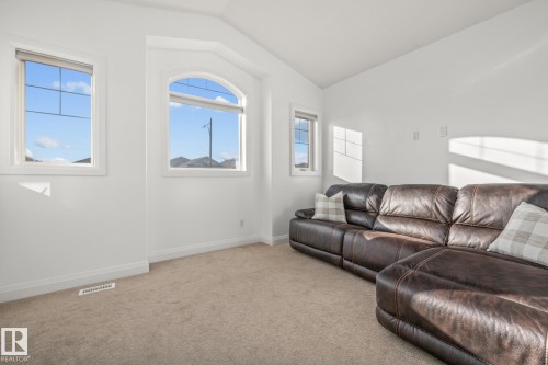 Carpeted living area featuring baseboards and vaulted ceiling - 167 Bremner Crescent, Fort Saskatchewan, AB - Indoor Photo Showing Living Room
